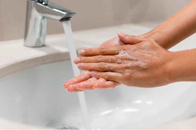 Pessoa lavando as mãos. 